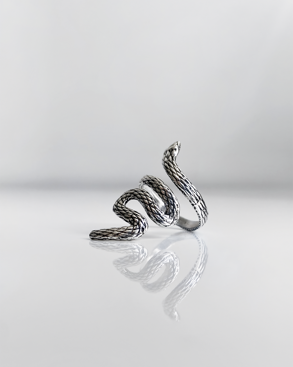 Bague HELLES modèle Boa en laiton argenté patiné en forme de serpent ajustable, design détaillé et texturé.