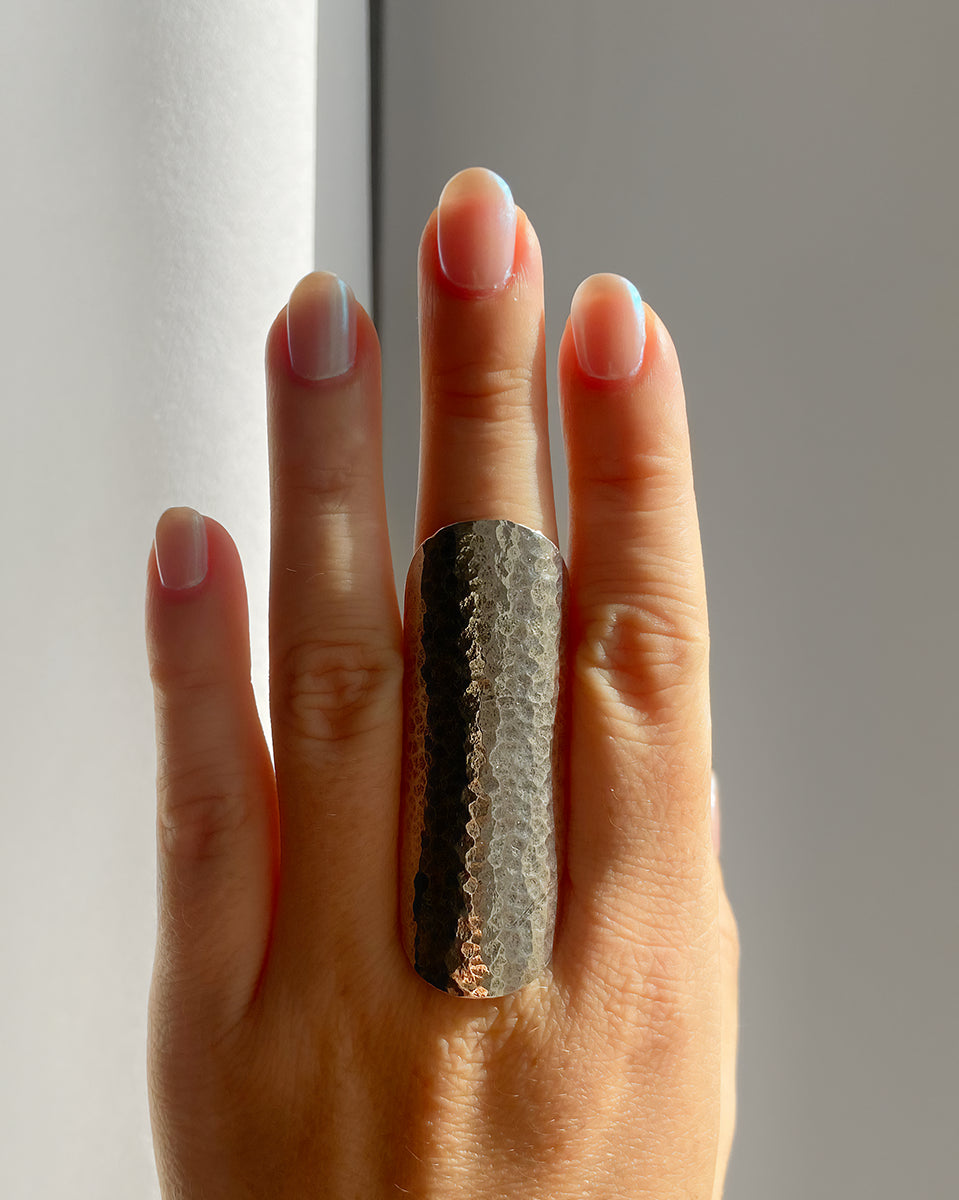 Bague boho HELLES large en laiton argenté patiné avec une texture martelée, portée sur un doigt