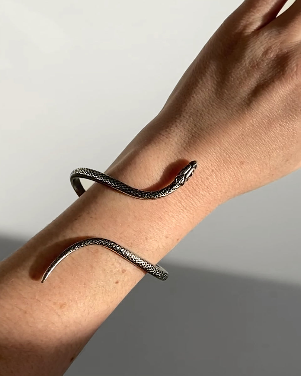 Bracelet enroulé HELLES en forme de serpent en laiton argenté patiné, ajustable, porté au poignet.