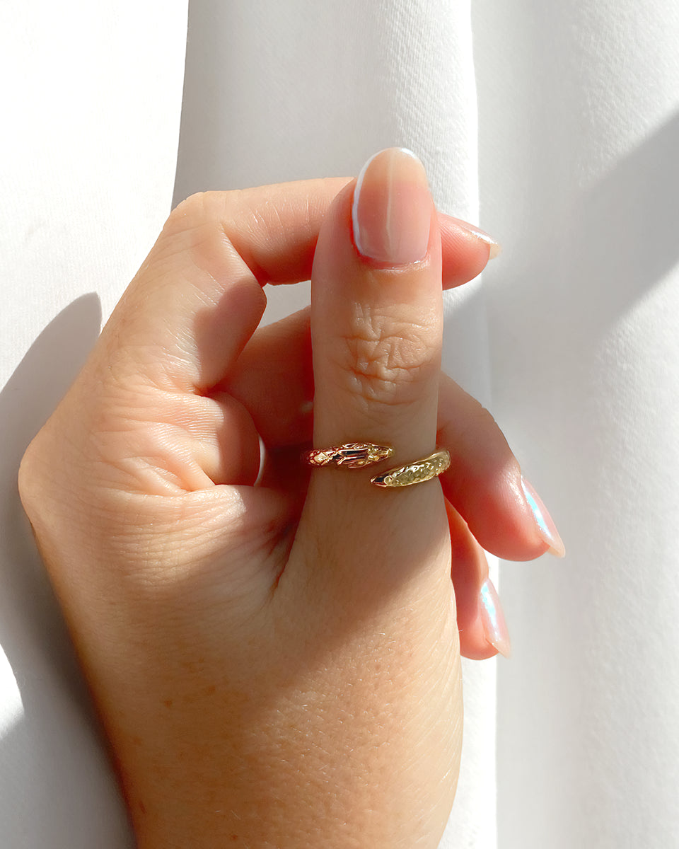 Bague ajustable HELLES Baby Snake en laiton doré à l'or fin 24 carats portée sur un doigt