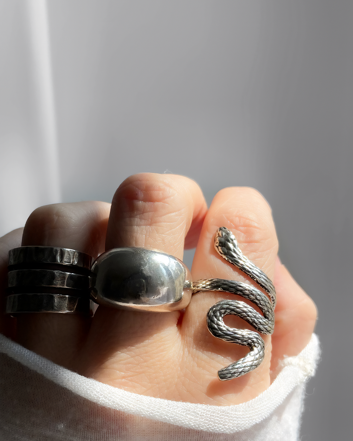 Bague BOA HELLES ajustable en forme de serpent en laiton argenté et patiné portée sur un doigt