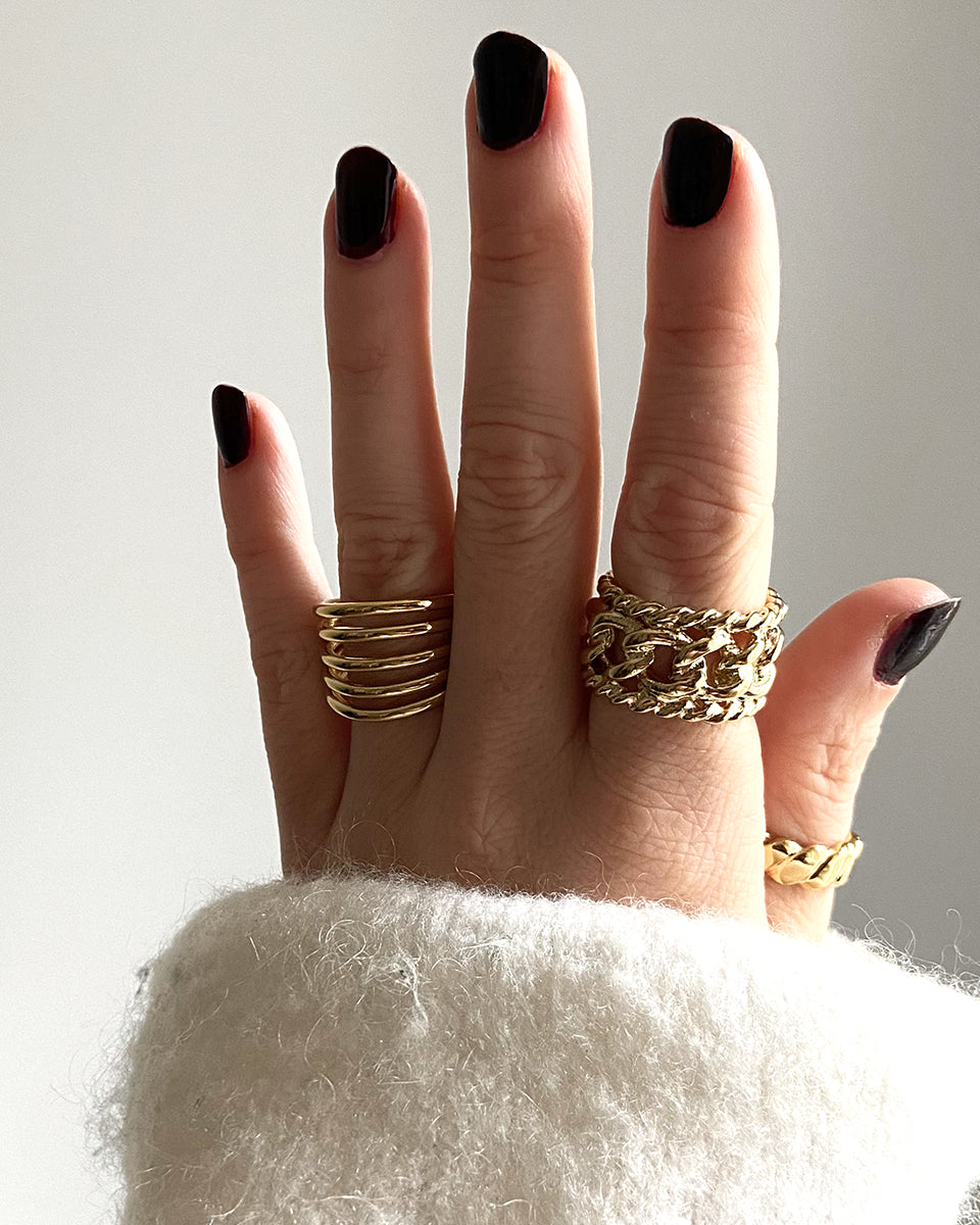 Bague Rock HELLES ajustable en laiton doré à l'or fin 24 carats portée sur un doigt avec d'autres bagues