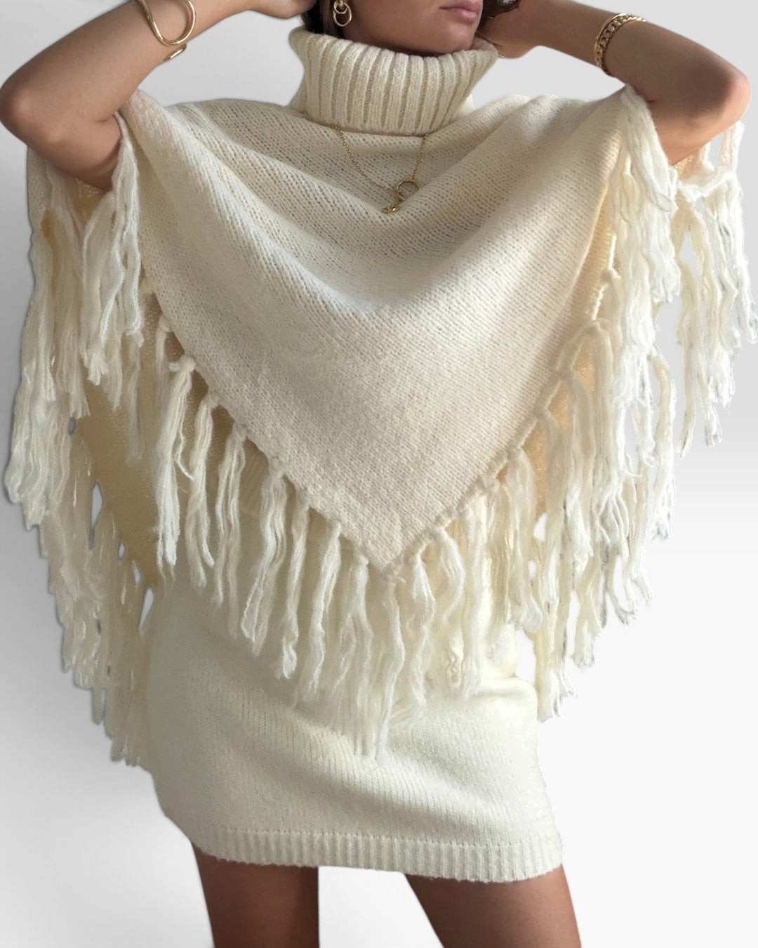 Jupe courte HELLES en maille crème douce et extensible, portée avec un poncho assorti à franges pour un look cosy