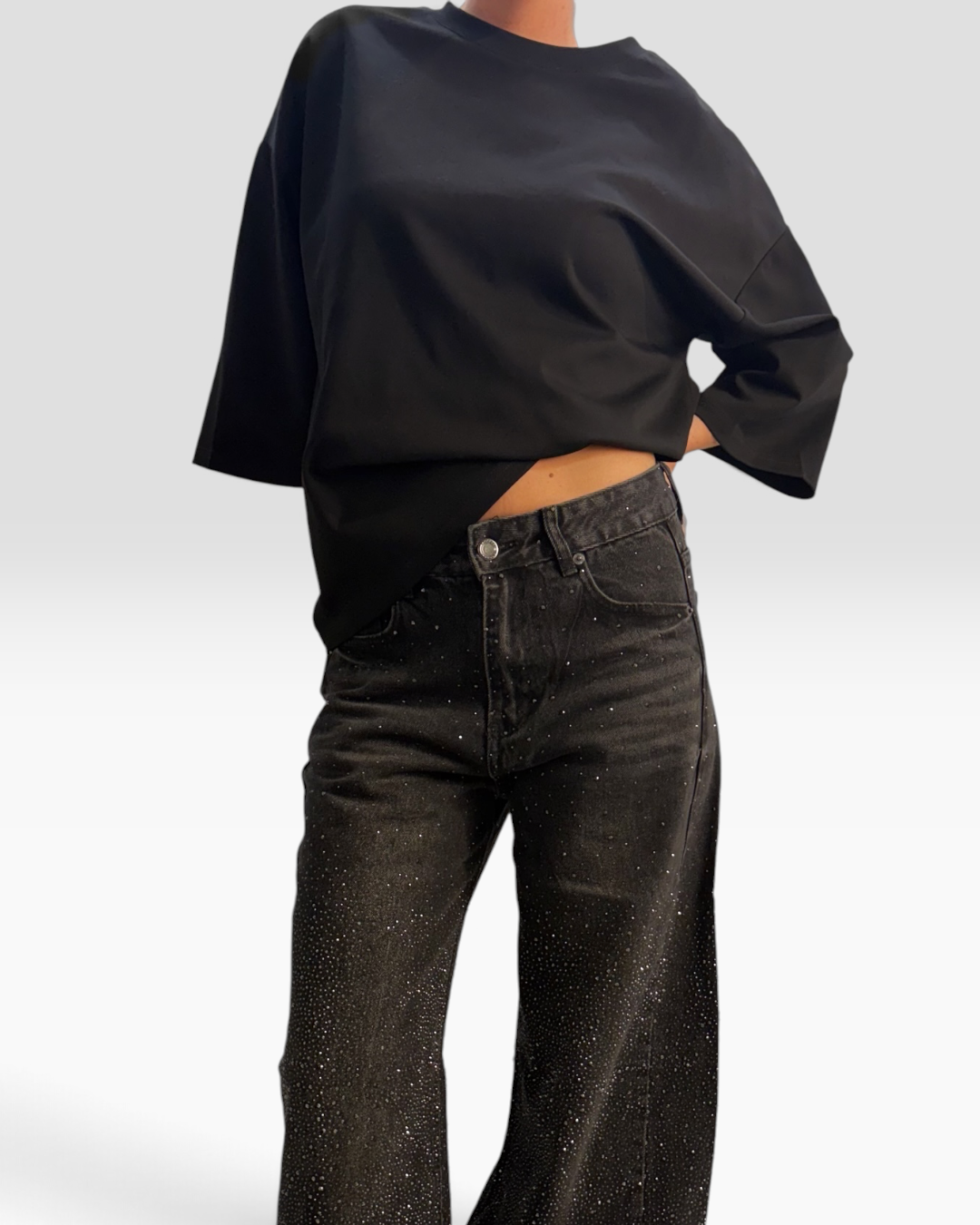Tee-shirt noir HELLES à coupe décontractée porté avec un jean sombre, idéal pour un look décontracté.